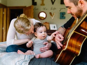 Baby listening to daddy play guitar
