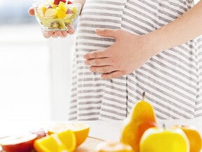 Pregnant women eating fruit salad