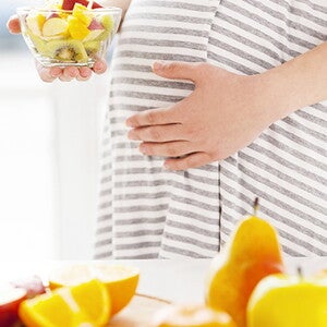 Pregnant women eating fruit salad